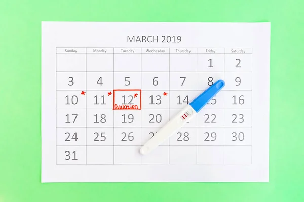 Positive pregnancy test with circling date in calendar. Planning of pregnancy, trying to have baby. — Stock Photo, Image