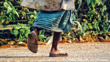 Yaşlı bir adam sabah erken saatlerde parkta yürüyor.