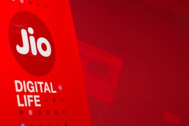 Delhi, Hindistan - Ekim 05, 2020: Jio SIM kartları her JioFi ya da 4G akıllı telefonunun kırmızı arka planı vardır