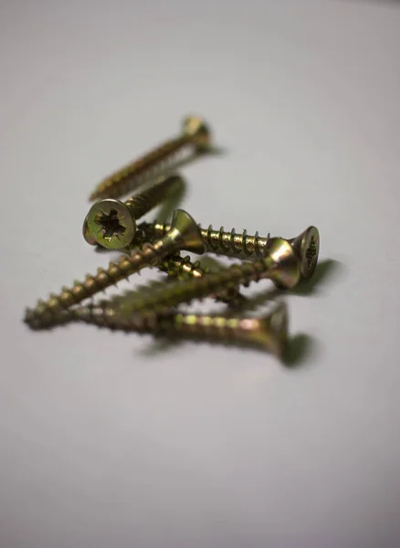 Set of screws close up. Macro photo of screws on a white background. Building abstraction. Industrial background. Macro photo screws, screw background, steel screw, selective focus. — Stock Photo, Image