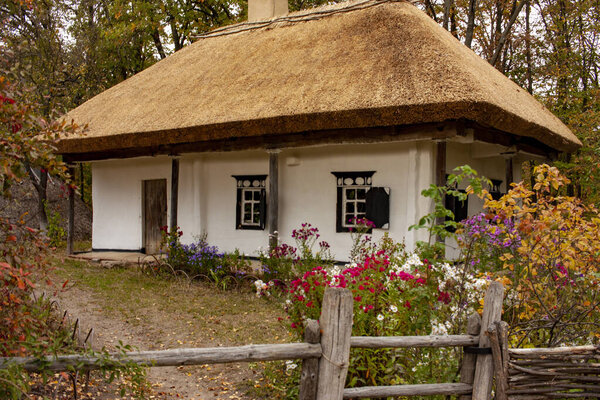 Old rural wooden house with thatched roof. Fall season. Close-up.