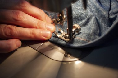 Eski bir dikiş makinesinin kadın eli, dikiş kotu. Yakın plan.