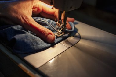 Eski bir dikiş makinesinin kadın eli, dikiş kotu. Yakın plan.