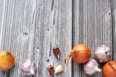 Sarımsak kafalar, koyu ahşap bir masada soğan, yazı için yeri olan üst manzara..