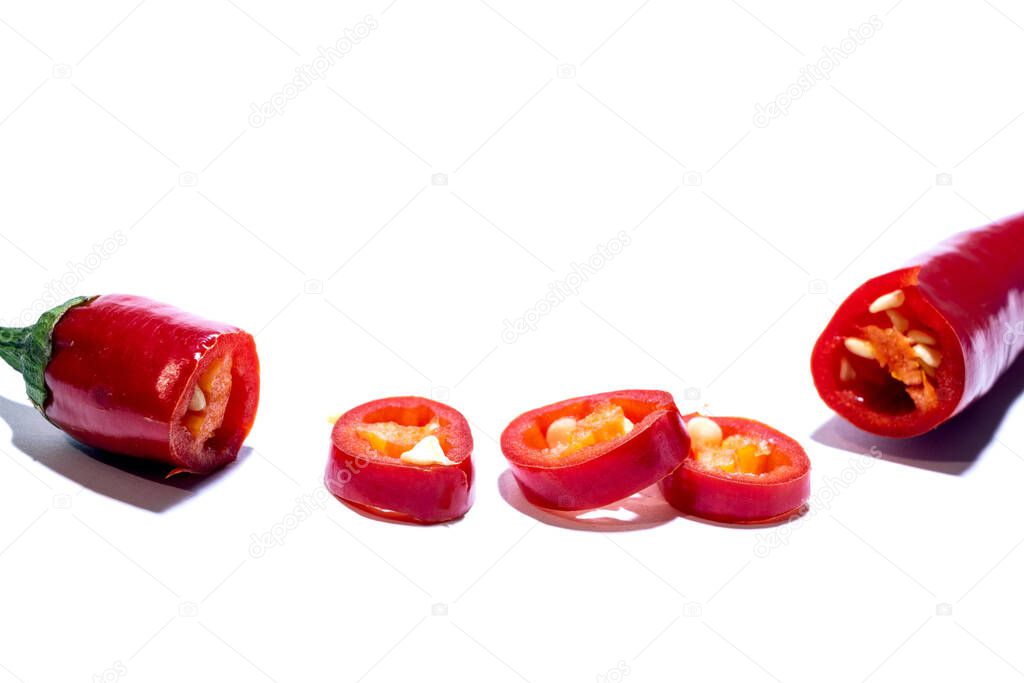 Fresh red juicy chili peppers in a cut on round rings isolated on white