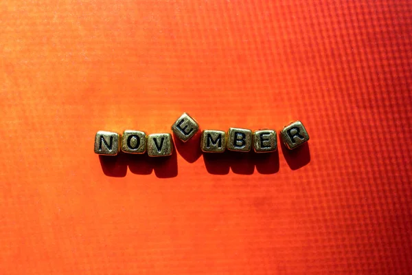 Listopad Miesiąc Znak Tekstowy Kolorowym Jasnoczerwonym Tle Napis Kostkach Strona — Zdjęcie stockowe