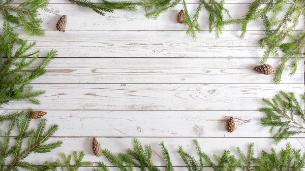Noel arkaplanı. Yeni yıl, Flatlay. Yeşil Noel ağacı, süsleri ve oyuncakları hafif ahşap arka planda. Metin için en üstteki görünüm. Mutlu Noeller..