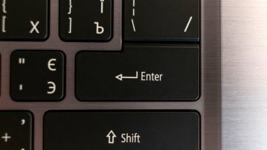 Dizüstü bilgisayar klavyesini kapat. Metal bir arka planda siyah İngiliz harfleri. Yukarıdan görüntüle.