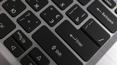 Dizüstü bilgisayar klavyesini kapat. Metal bir arka planda siyah İngiliz harfleri. Yukarıdan görüntüle.