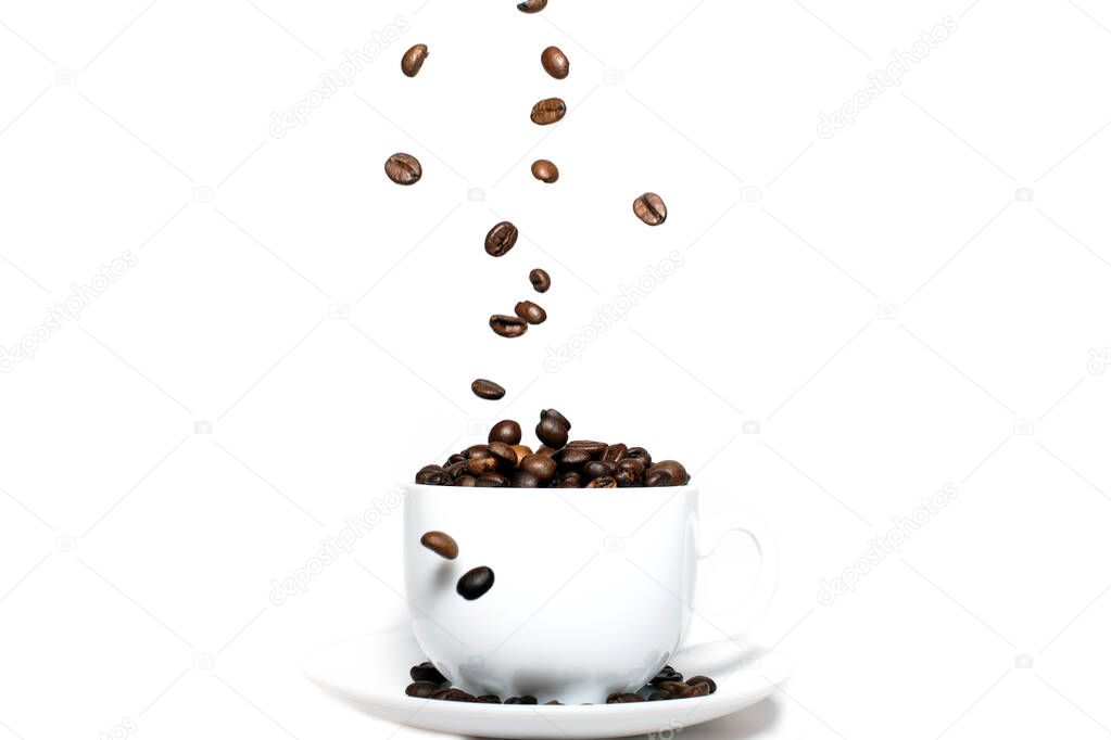 Roasted coffee beans falling into coffee cup on saucer with white background,fresh and bright wallpaper concept.