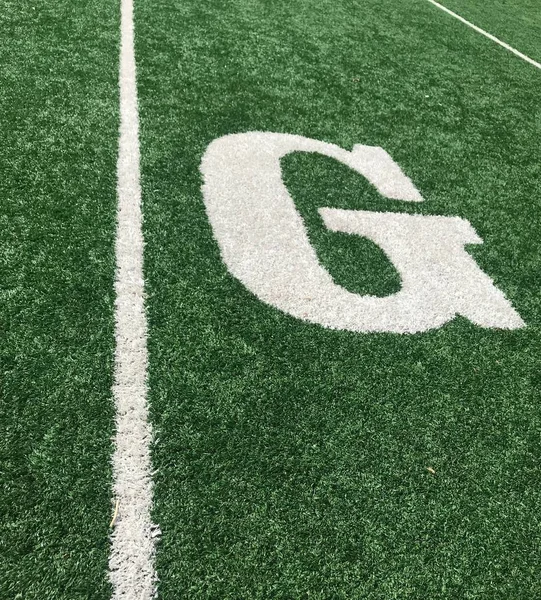 Letter G on the goal line of football field