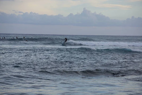 サーファーはカウアイのPoipu Beachで夕方にいくつかの最終波をキャッチします — ストック写真