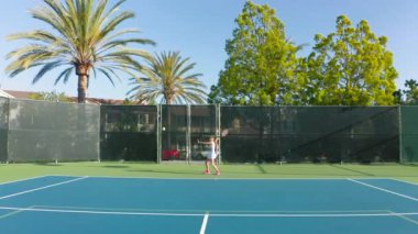 Güçlü genç bir sporcunun maç boyunca tenis topuna yavaş çekimde vurması.