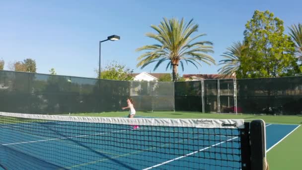 Slow-motion zicht door de tennisbaan net van atleet raken van de bal — Stockvideo