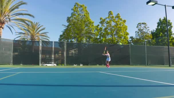 Al rallentatore di una partita di tennis. Un atleta donna corre e colpisce la palla. — Video Stock