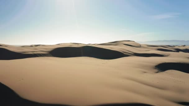 4K vue aérienne de drone volant par de belles dunes de sable ondulées dans la lumière dorée du coucher du soleil — Video