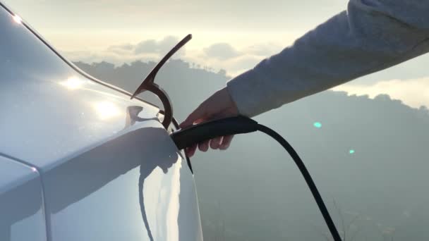4К замедленного движения женщины вынимает кабель питания из нулевой эмиссии электромобиля — стоковое видео