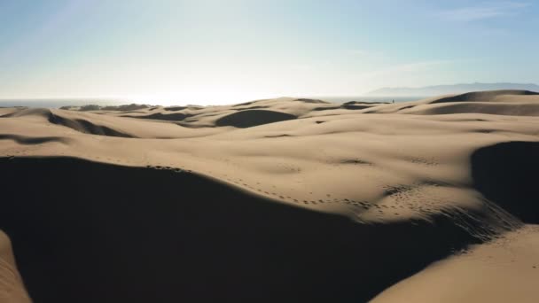 4K vue aérienne de drone volant par de belles dunes de sable ondulées dans la lumière dorée du coucher du soleil — Video