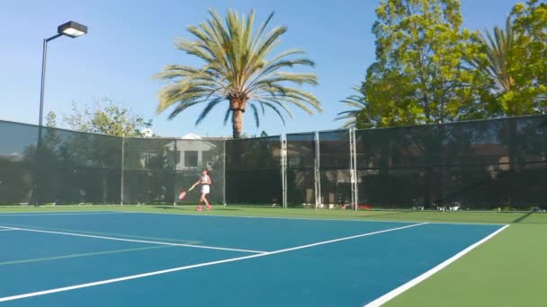 Spowolnienie ruchu kobiety sportowiec gra w tenisa mecz uderzając piłkę na korcie — Wideo stockowe