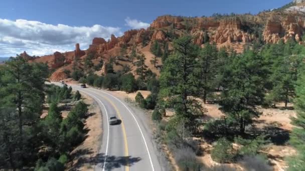 美しい赤い岩の形成や道路上の4K空中。ブライス・キャニオン,ユタ州,アメリカ — ストック動画