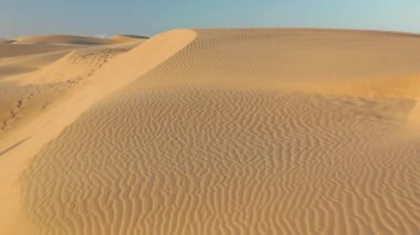 Hafif gün doğumu ışığında inanılmaz dalgalı kum tepecikleri, 4K hava gözlem insansız hava aracı.