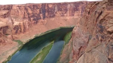 4K insansız hava aracı yeşil Colorado nehri ile güzel kırmızı Büyük Kanyon 'da uçuyor.