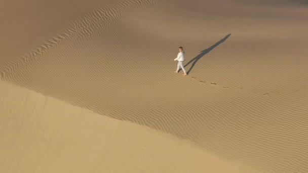 4K câmera lenta vista aérea da mulher andando pelo pico da duna de areia, EUA natureza — Vídeo de Stock