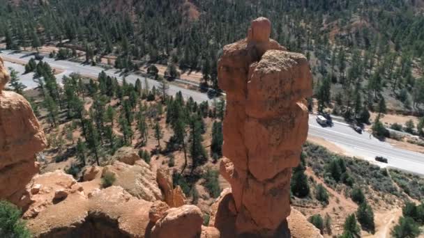 ブライス・キャニオン,ユタ州,アメリカ.美しい赤い岩の形成と道路上の4K航空 — ストック動画