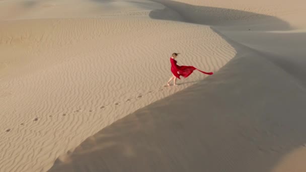 4K vue aérienne de la femme restant au sommet de la dune de sable au coucher du soleil — Video