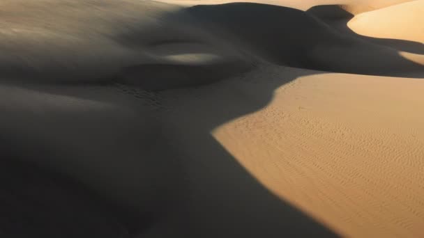 4K-Drohnenbild, das durch wunderschöne wellige Sanddünen in goldenem Sonnenuntergang fliegt — Stockvideo