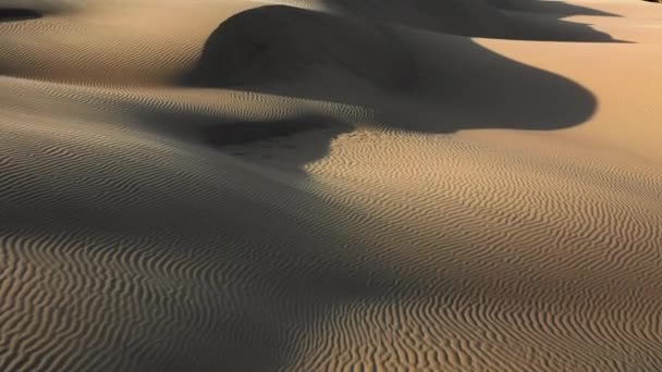 Vista aérea del dron 4K volando por hermosas dunas de arena ondulada en luz dorada del atardecer — Vídeos de Stock