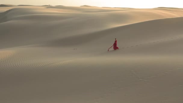 Femme marchant dans la nature sauvage du désert. 4K slow motion vue aérienne des dunes de sable