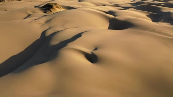 4K Contexte abstrait. Drone survolant les dunes de sable au coucher du soleil doré — Video