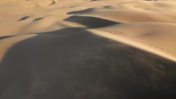 4K filmová anténa silného větru foukajícího zlatý písek z dun při západu slunce — Stock video