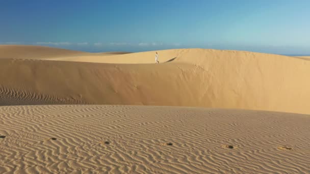 4K câmera lenta de mulher em sportswear andando por dunas de areia — Vídeo de Stock