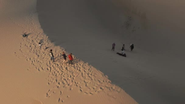 4K slow motion aerial view of people relaxing on the peak of sand dune, USA nature — Stock Video