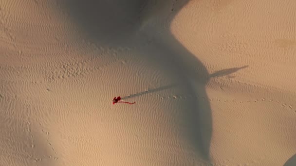 La gente ha sparato. 4K vista aerea della donna che cammina dalle dune al tramonto — Video Stock