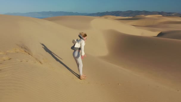 4K slow motion vue aérienne de femme heureuse sautant sur les dunes de sable, USA nature