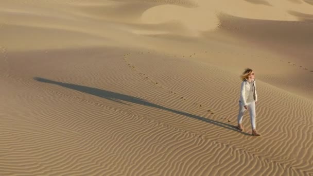 Voyage nature 4K vidéo aérienne. Jeune femme marche près des dunes de sable