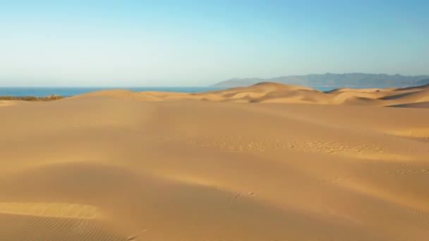 Drone elevándose por encima de enormes dunas de oro escénicas al amanecer. Imágenes aéreas 4K — Vídeo de stock