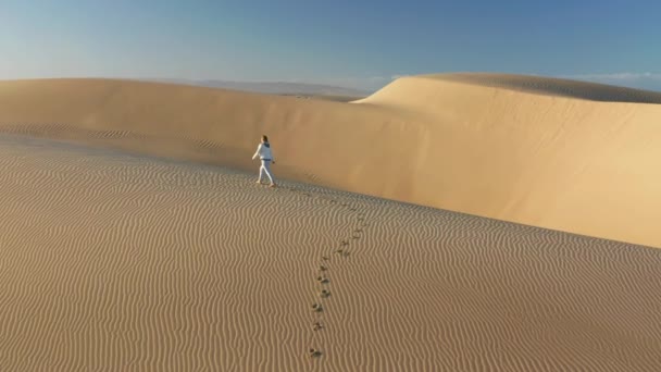 4K ralenti aérien de la femme marchant par le sommet de la dune dorée, USA nature