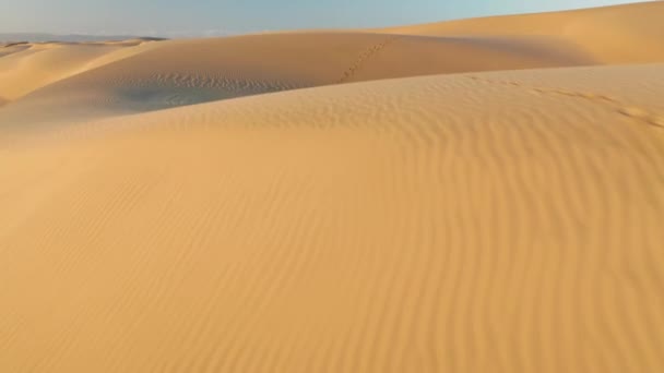 İnanılmaz dalgalı kum tepeleri, hafif gün doğumu ışığı, 4K hava gözlem insansız hava aracı. — Stok video