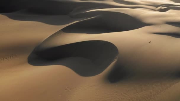 Vista aérea del dron 4K volando por hermosas dunas de arena ondulada en luz dorada del atardecer — Vídeo de stock