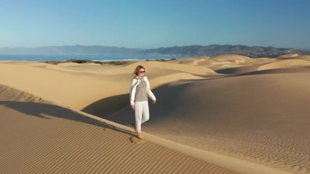 4K câmera lenta vista aérea da mulher feliz correndo pelas dunas de areia, EUA natureza — Vídeo de Stock