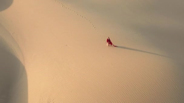 4K drone vista remota de una mujer caminando por dunas de arena en la naturaleza del desierto, EE.UU. — Vídeo de stock