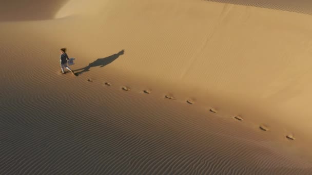 4K slow motion аэрофотоснимок женщины, бегущей по песчаной дюне, пустынная природа США — стоковое видео