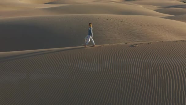 4K slow motion vue aérienne de la femme marchant au sommet d'une dune de sable, USA nature
