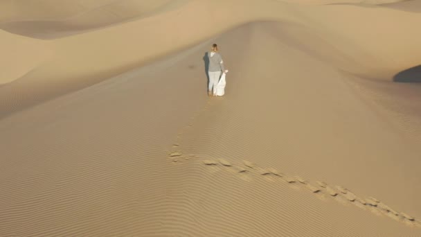 4K slow motion luchtfoto van de vrouw wandelen door de piek van zand duin, USA natuur — Stockvideo