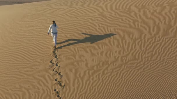 4K zpomalení letecký pohled ženy lezení na vrchol písečné duny, USA příroda — Stock video