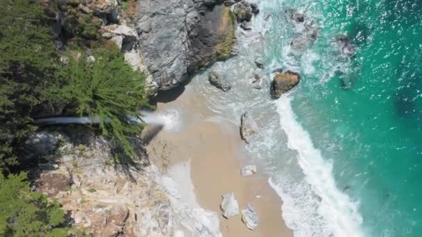 4K letecký pohled shora dolů na vodopád kapající z mořského útesu do oceánu — Stock video